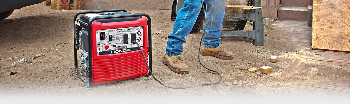 A 2017 Honda EB2800i generator on the ground giving power to a power tool
